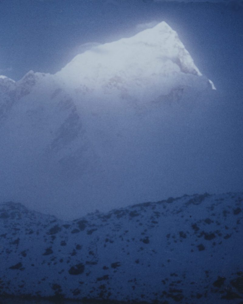 a mountain peak with snow and sunlight
